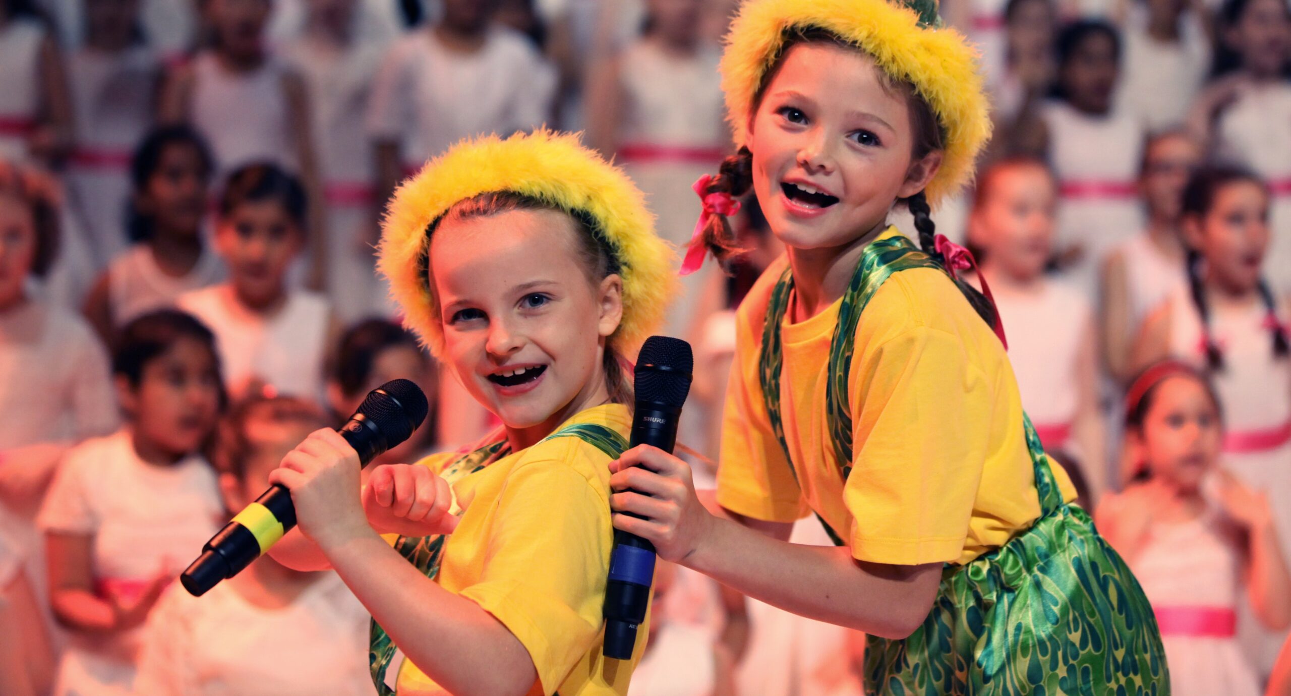 ASPA Education Performing Arts Holiday Program_Two girls wearing yellow tshirt and halo with green shorts with braces smiling