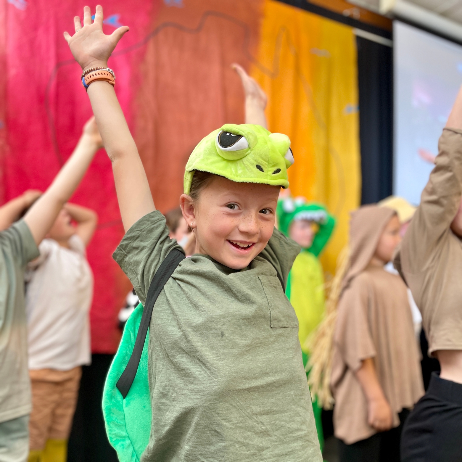 An Aussie Adventure cast member throws her arms up in the air