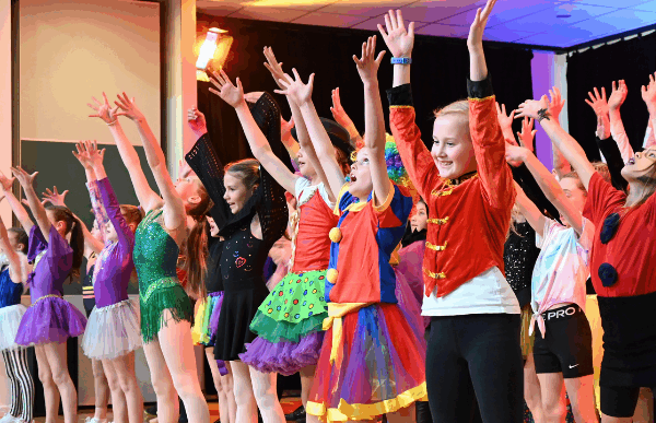 Children performing on stage in costumes