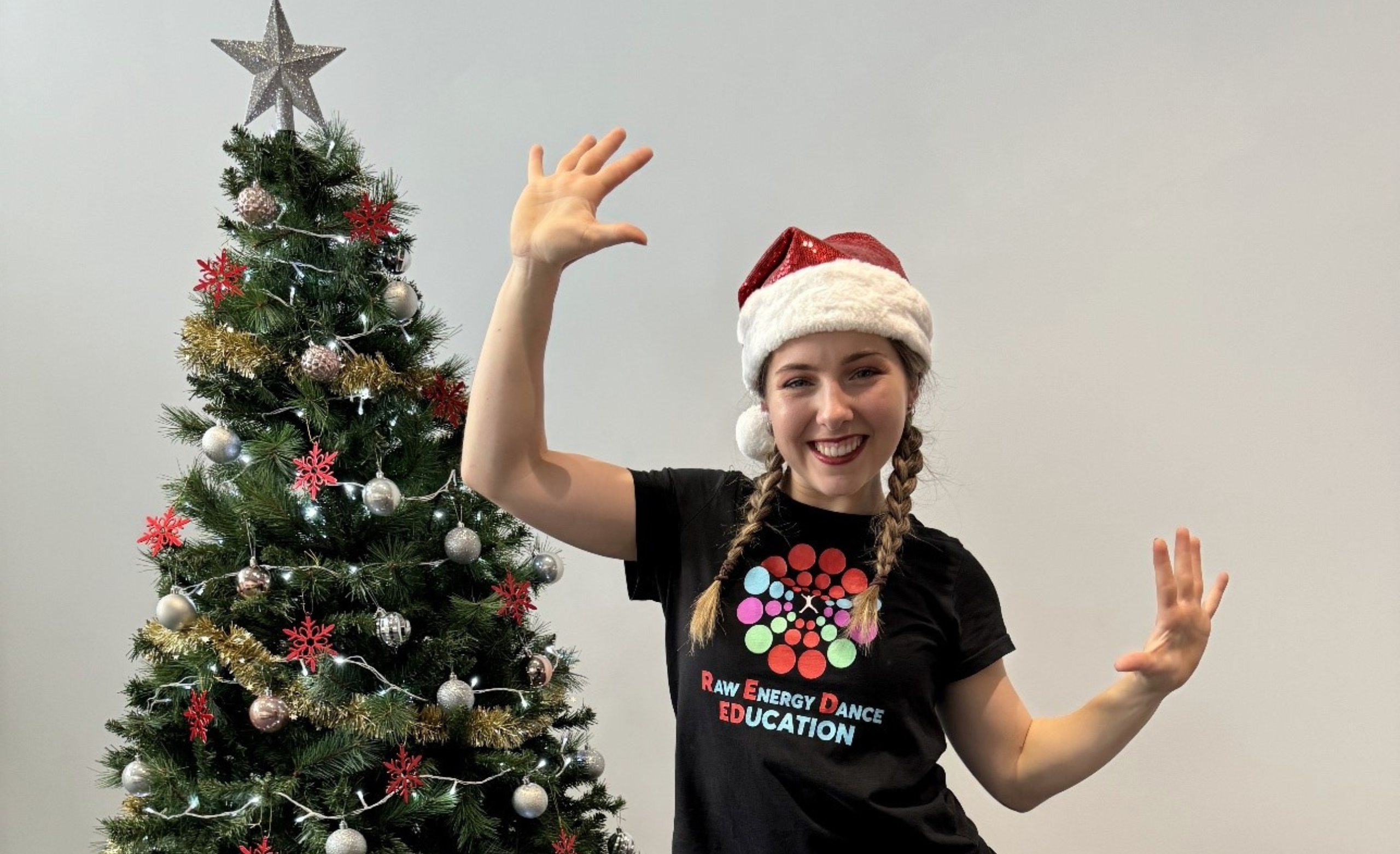REDed instructor in logo black shirt in front of Christmas tree