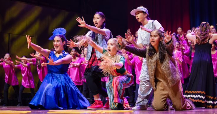 Young performers in costumes on stage